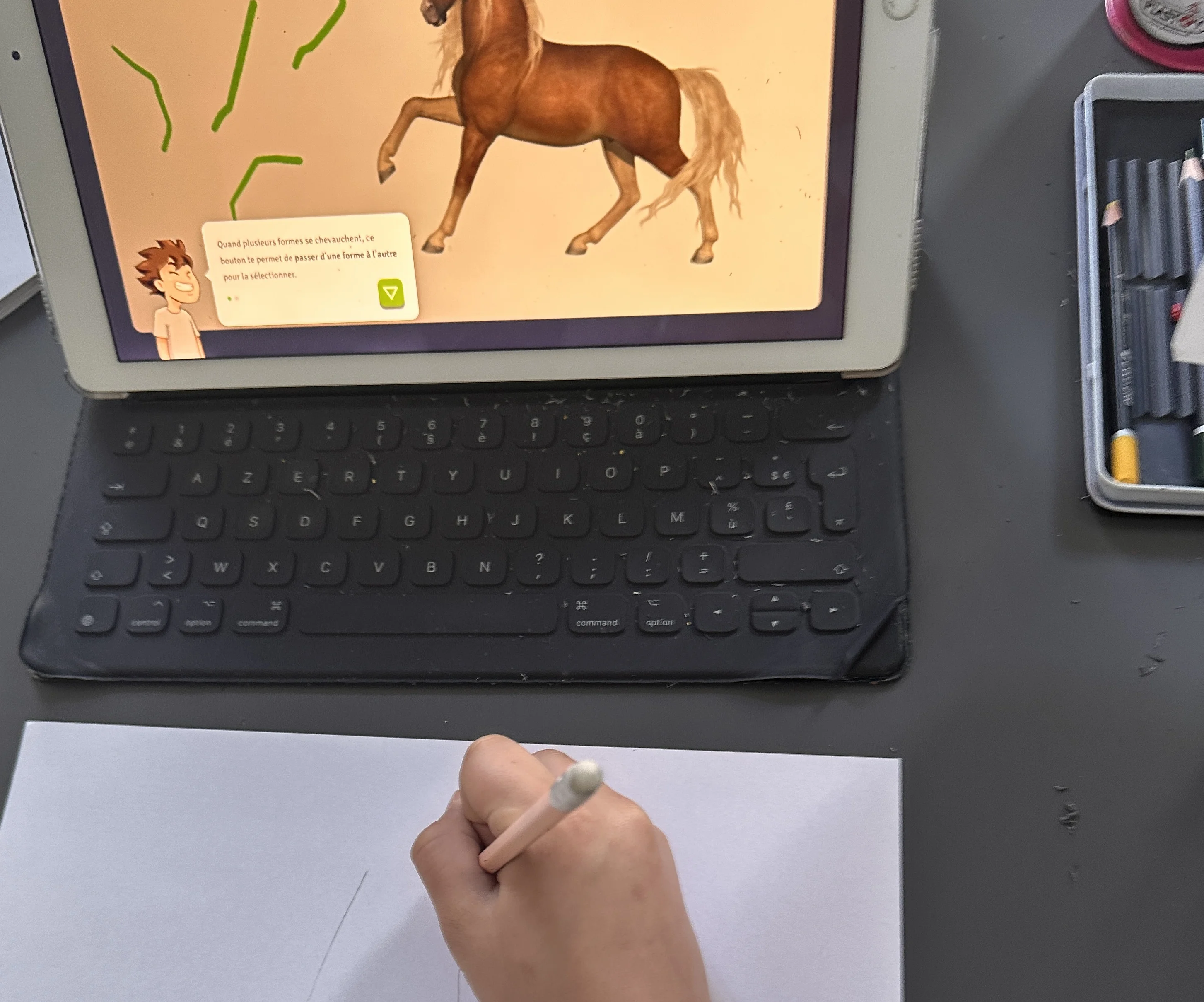 Enfant dessinant un cheval à l'aide d'un tutoriel sur tablette